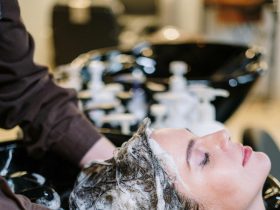 Progressiva Sem Formol: O Que É, Como Funciona e Quanto Dura em 2026 Mulher tendo cabelo lavado no salão durante progressiva sem formol