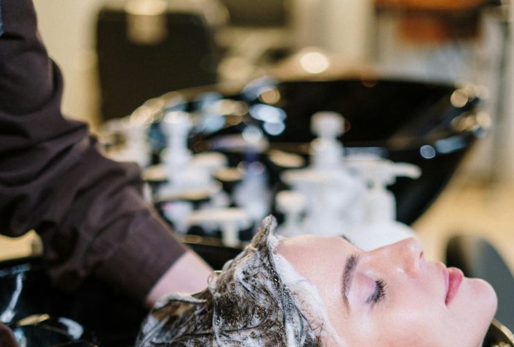 Progressiva Sem Formol: O Que É, Como Funciona e Quanto Dura em 2026 Mulher tendo cabelo lavado no salão durante progressiva sem formol