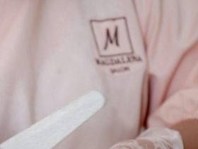 Unhas de Fibra de Vidro ou Acrílico: Qual é Melhor? Diferenças, Vantagens e Duração Manicure aplicando extensão de unhas no salão - fibra de vidro ou acrílico